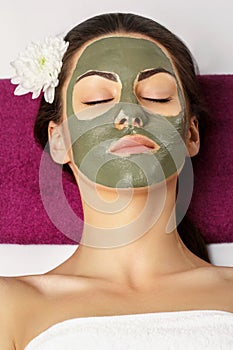 Woman with clay facial mask   in beauty spa. Skincare. Beauty Co