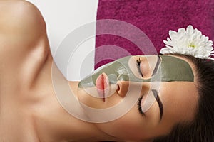 Woman with clay facial mask   in beauty spa. Skincare. Beauty Concept. Close-up portrait of beautiful girl with facial mask.Facial