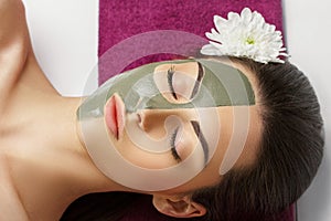 Woman with clay facial mask   in beauty spa. Skincare. Beauty Concept. Close-up portrait of beautiful girl with facial mask.Facial
