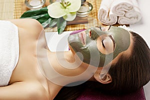 Woman with clay facial mask   in beauty spa. Skincare. Beauty Concept. Close-up portrait of beautiful girl with facial mask.Facial