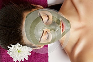 Woman with clay facial mask in beauty spa. Skincare. Beauty Concept. Close-up portrait of beautiful girl with facial mask.Facial t