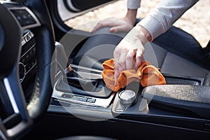 Woman clean car interior with microfiber, close up