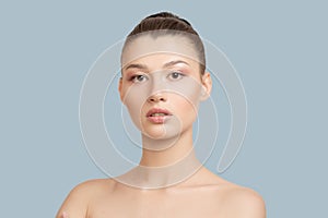 Woman with clean skin touches her cheeks with her hand. face skin concept on a blue background