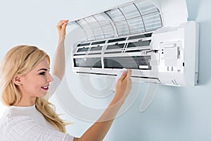 Woman Cleaning Air Conditioner