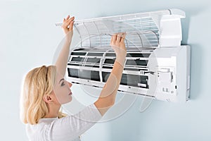 Woman Cleaning Air Conditioning System