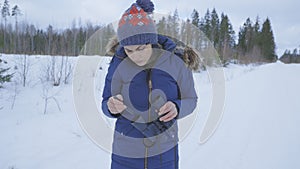 Woman cleaning binoculars in forest