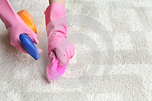 Woman cleaning carpet indoors