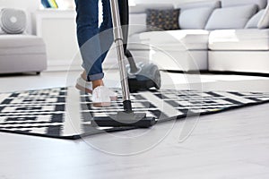 Woman cleaning carpet with vacuum cleaner