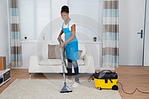 Woman Cleaning Carpet With Vacuum Cleaner