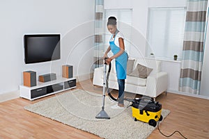 Woman Cleaning Carpet With Vacuum Cleaner
