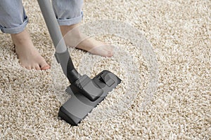 Woman cleaning carpet with vacuum cleaner, closeup. Space for text