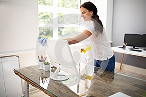 Woman Cleaning Computer In Office