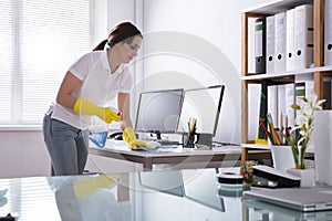 Woman Cleaning Computer In Office