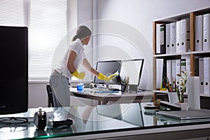 Woman Cleaning Computer In Office