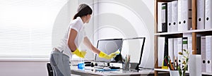 Woman Cleaning Computer In Office