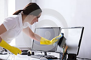 Woman Cleaning Computer In Office