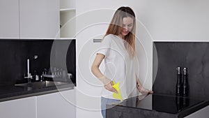 Woman cleaning cooking panel in kitchen with cloth