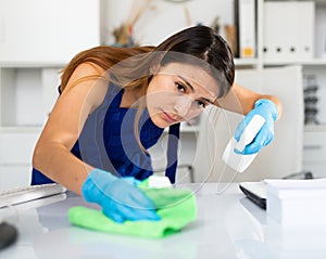 Woman cleaning desk in office