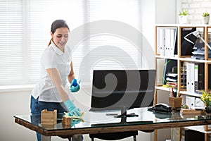 Woman Cleaning The Desk In Office