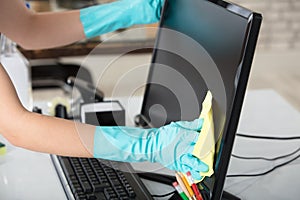 Woman Cleaning Desktop Screen With Rag