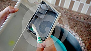 Woman cleaning detergent tray of washing machine close up view