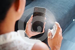 Woman Cleaning And Disinfecting Cell Phone Against Virus