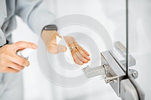 Woman cleaning door handle at home