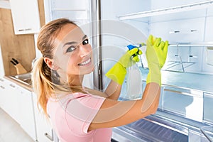 Woman Cleaning The Empty Refrigerator Door