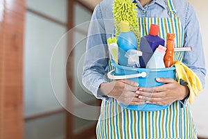 Woman with cleaning equipment ready to clean house in the room b