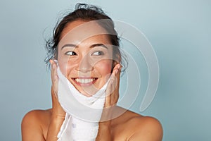 Woman cleaning facial skin with towel after washing face portrait photo