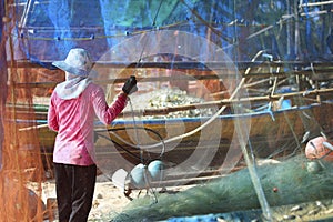 woman cleaning fish net ,after be back from fishing