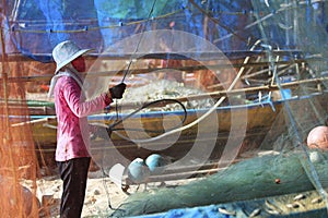 woman cleaning fish net ,after be back from fishing