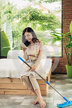 Woman cleaning floor with mop indoors. Relax after doing housework.