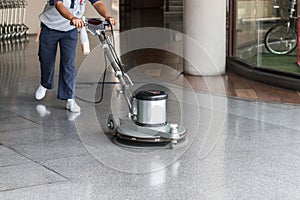 Woman cleaning the floor with polishing machine