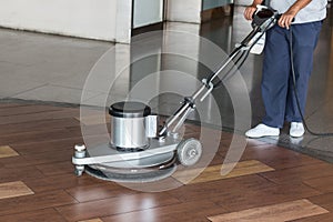 Woman cleaning the floor with polishing machine photo