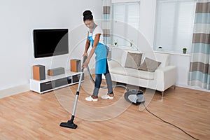 Woman Cleaning Floor With Vacuum Cleaner photo