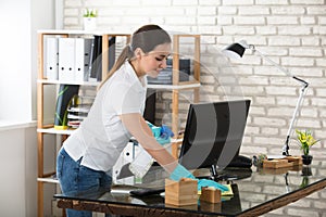 Woman Cleaning The Glass Office Desk