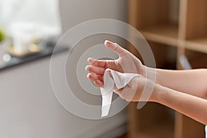 Woman cleaning hands with antiseptic wet wipe