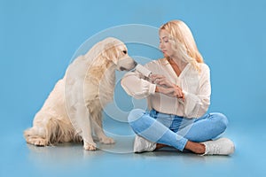 Woman cleaning her clothes from dog fur with adhesive roller