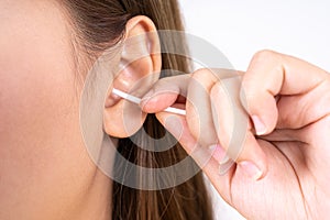 Woman cleaning her ear with a cotton swab. A woman suffered an infection after using the sticks incorrectly