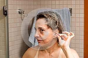 Woman Cleaning her Ears with a Cotton Tip Swab