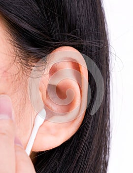 Woman is cleaning her ears with white cotton bud. Personal hygiene concept.