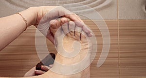 Woman cleaning her feets by pumice in bath