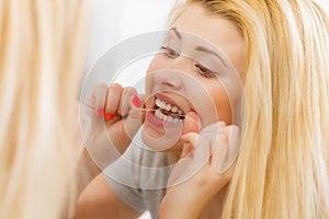 Woman cleaning her teeth using dental floss