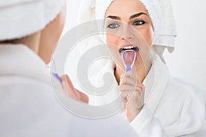 Woman cleaning her tongue