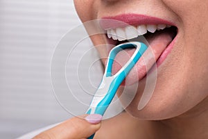 Woman Cleaning Her Tongue With Cleaner