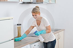 Woman Cleaning Kitchen Counter With Sponge