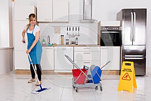 Woman Cleaning Kitchen Floor With Mop