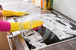 Woman cleaning kitchen stove