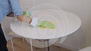 Woman cleaning the kitchen table with a cloth